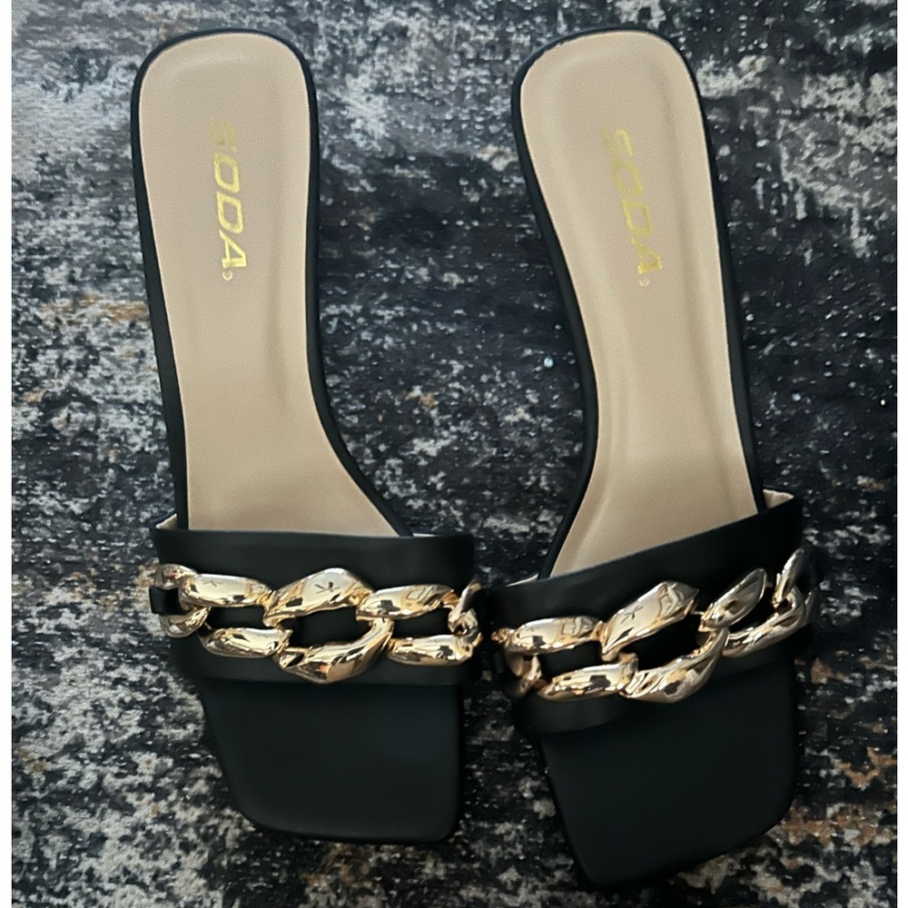 Soda black slip on sandals with large gold chain link accent